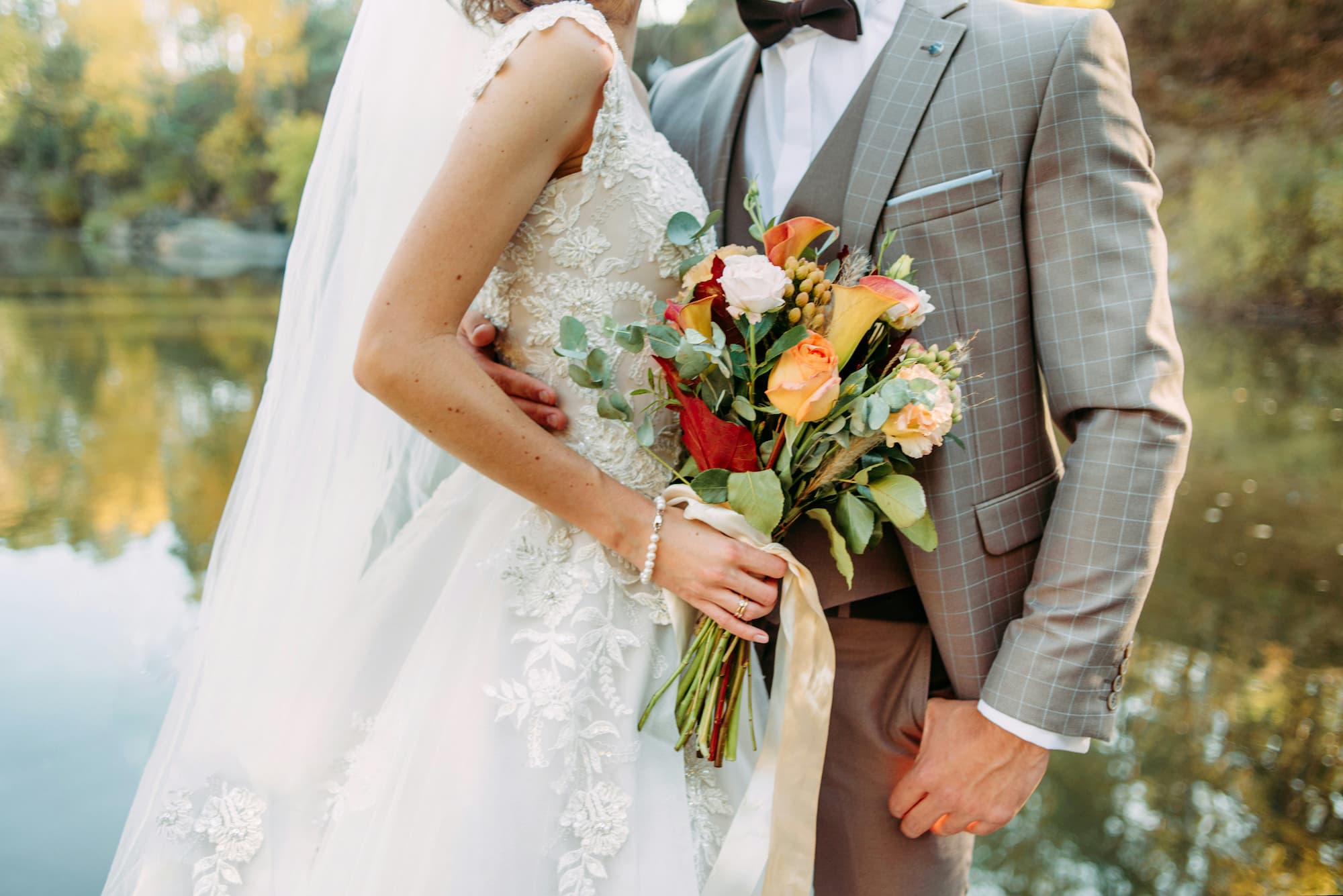 Bride and groom holding a floral bouquet